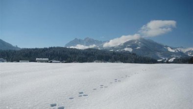 Wilder Kaiser und Loipe vor dem Haus