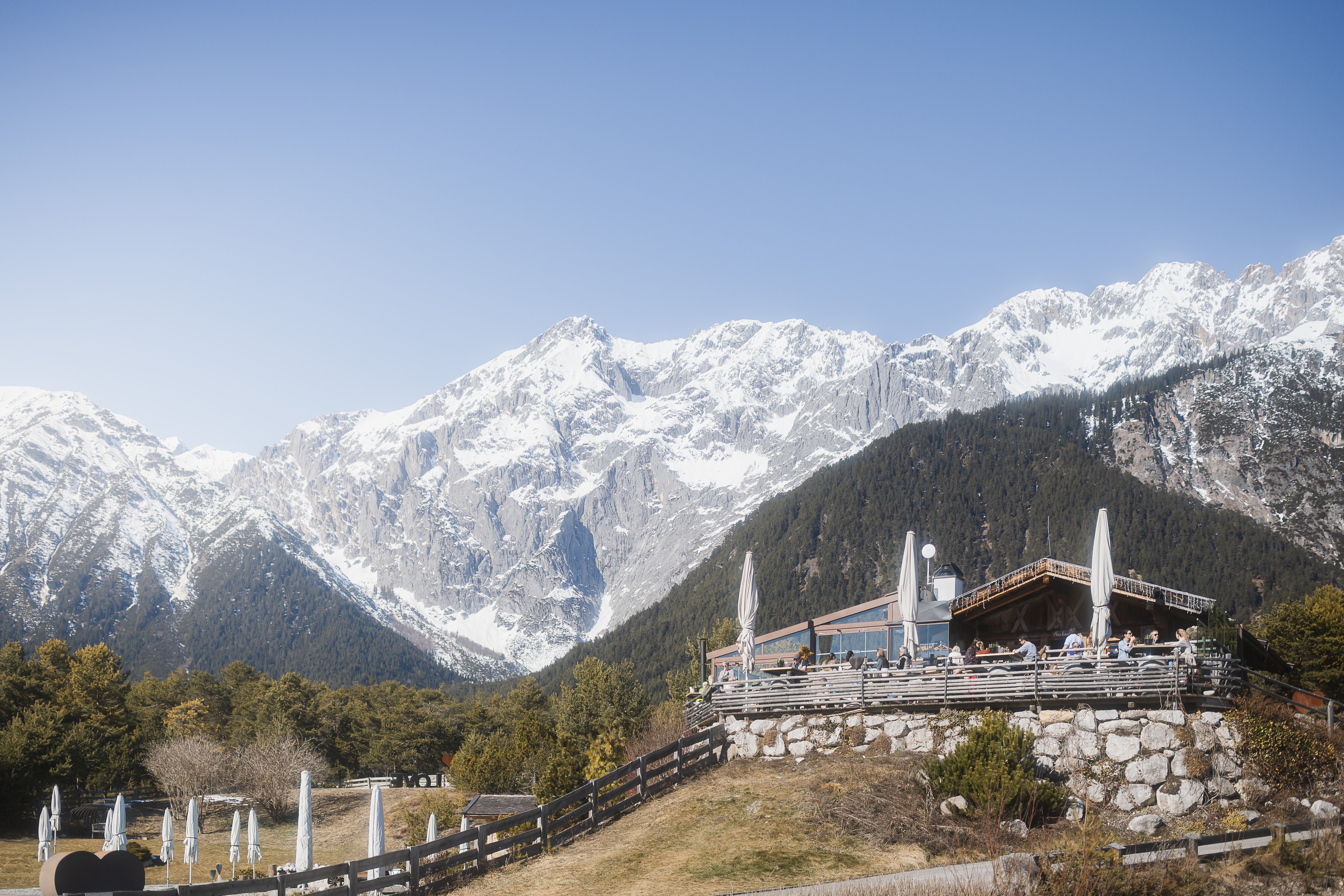 Stöttlalm Mieminger Plateau im Frühling, Almhütte vor verschneiter Bergkette