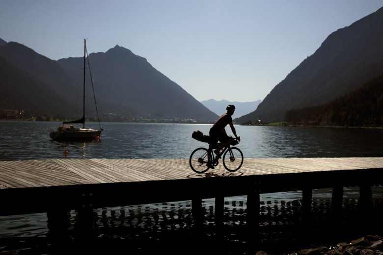 The &quot;Sea of Tirol&quot;: Valentin cycling along a boardwalk at Lake Achensee.
