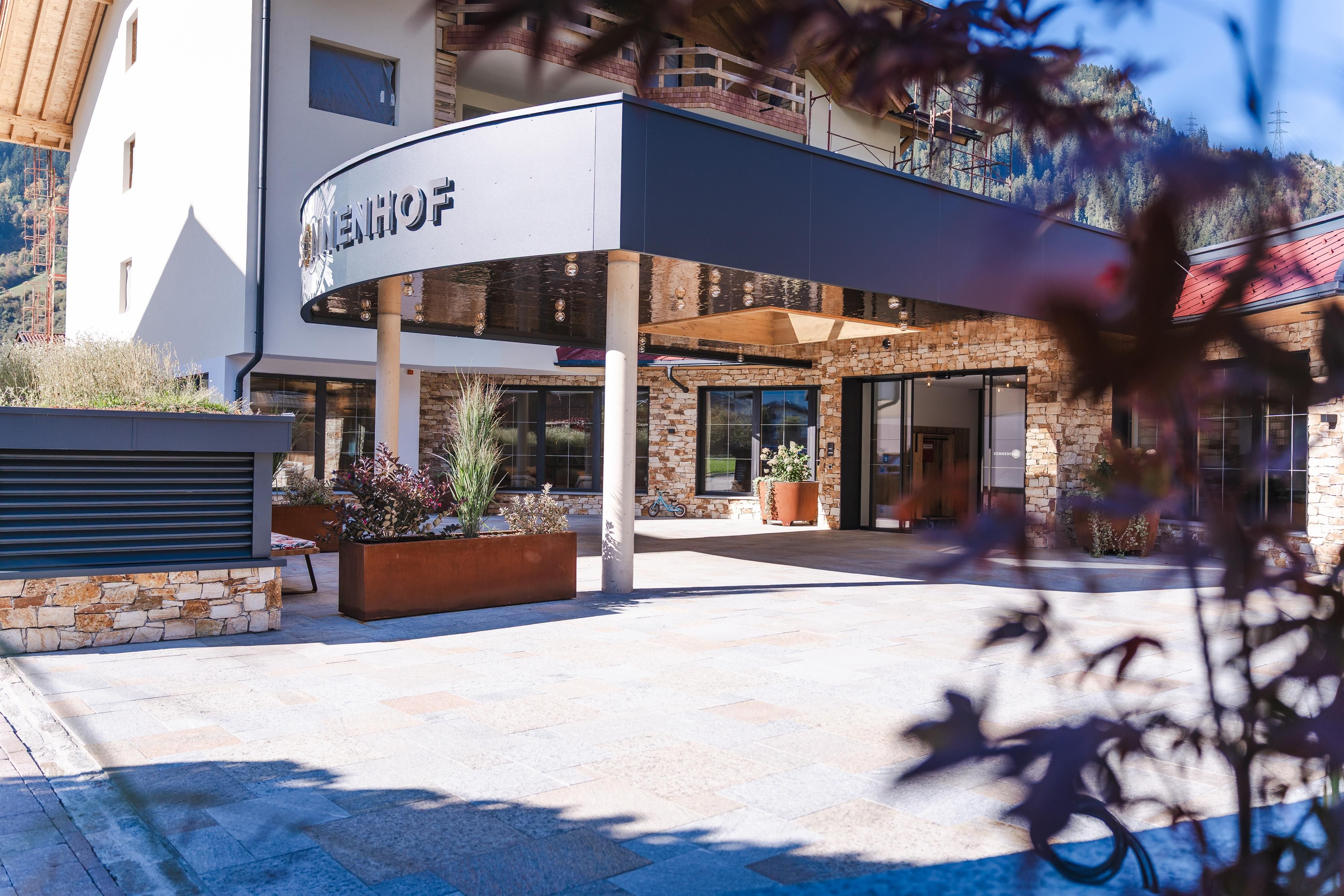 A modern building with an inviting entrance area. The surroundings are well-maintained and friendly designed.