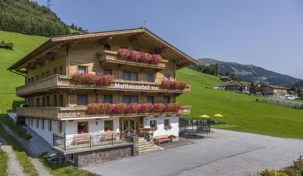 A charming wooden house in alpine style with colorful flowers. Surrounded by green meadows and mountains, it offers an inviting atmosphere.