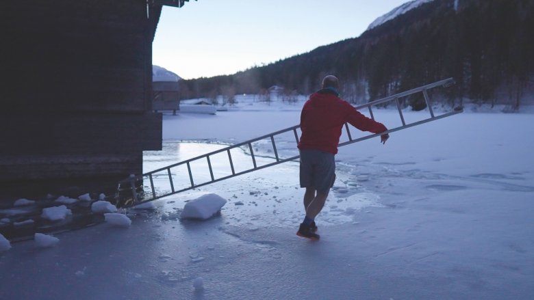 Breaking the ice. Josef K&ouml;berl uses a metal ladder to remove the thin layer of ice that has formed on the Tristacher See lake.
