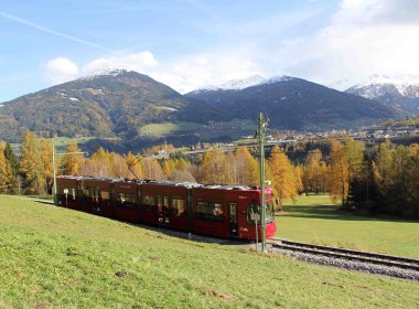 The Tram winds and turns and zigzags and goes through rolling green meadows on its way to Fulpmes in Stubaital Valley. Pictured in the rear is snow-flecked Patscherkofel, the iconic mountain in Innsbruck’s backyard. (Copyright: Haisjackl)
