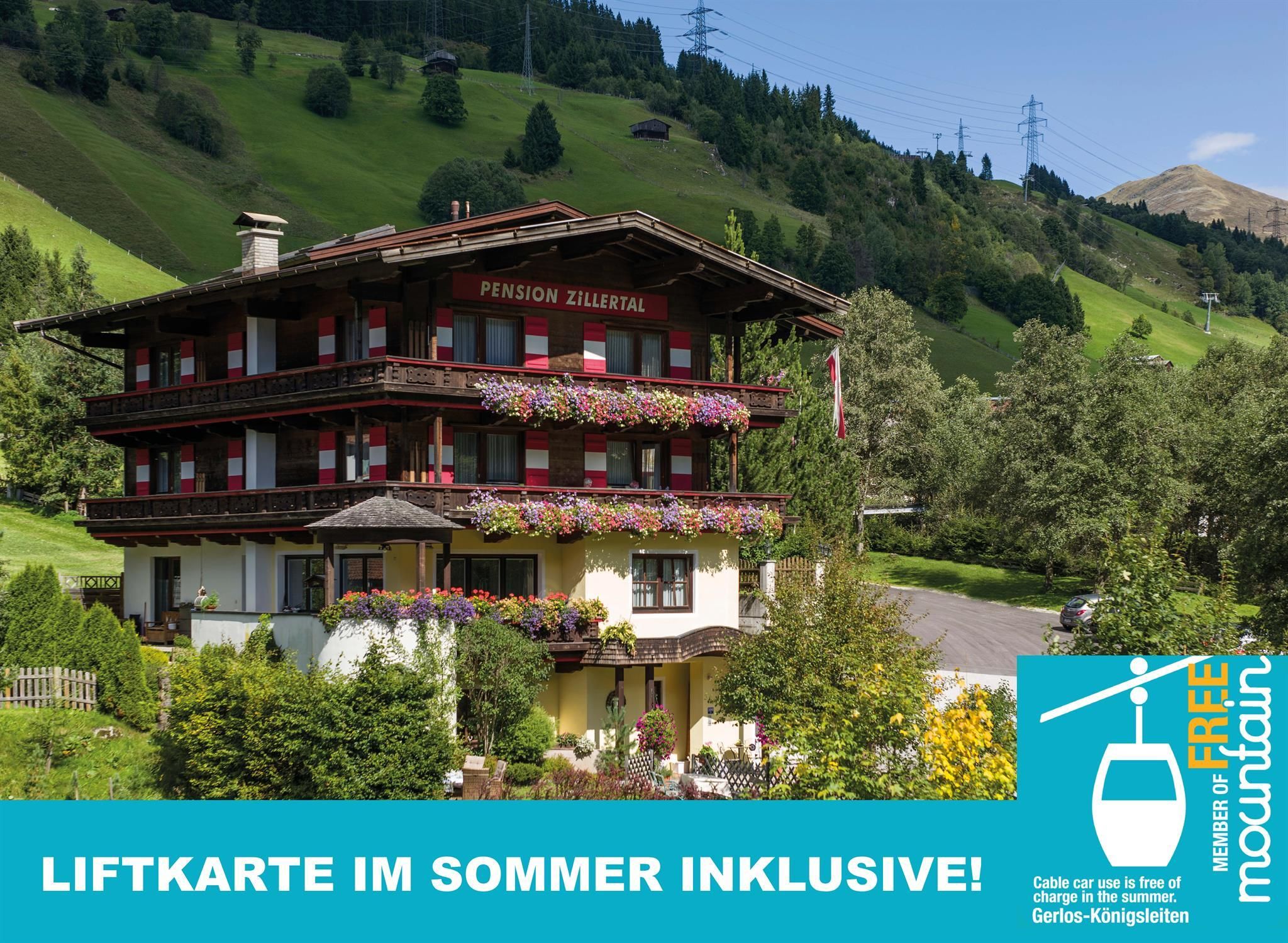 A picturesque holiday home with blooming balconies in a green mountain landscape. The surroundings are idyllic and inviting.