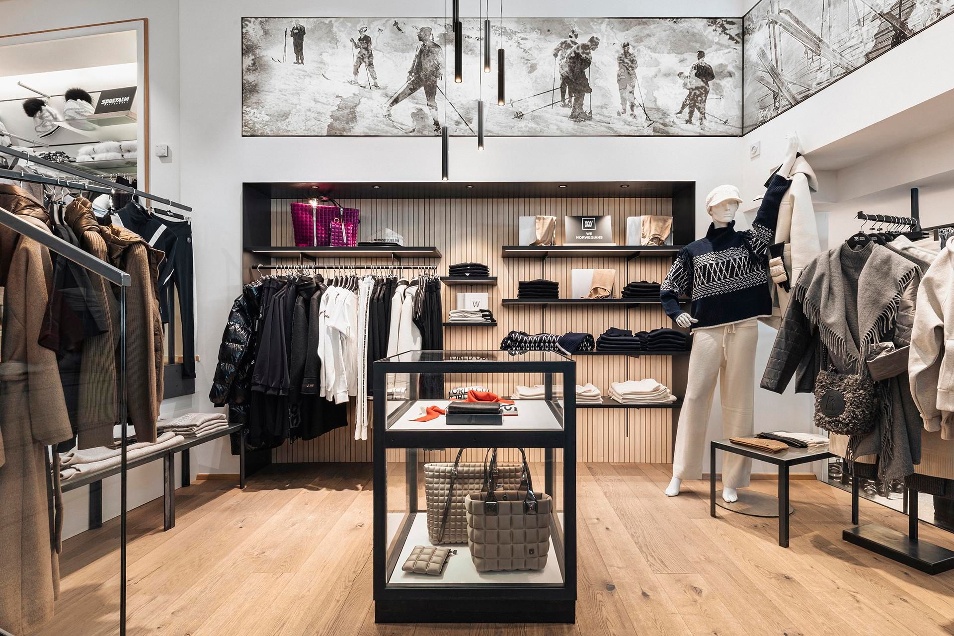An elegant fashion store with stylish clothing and accessories. The bright wooden floors and modern shelves create an inviting atmosphere.