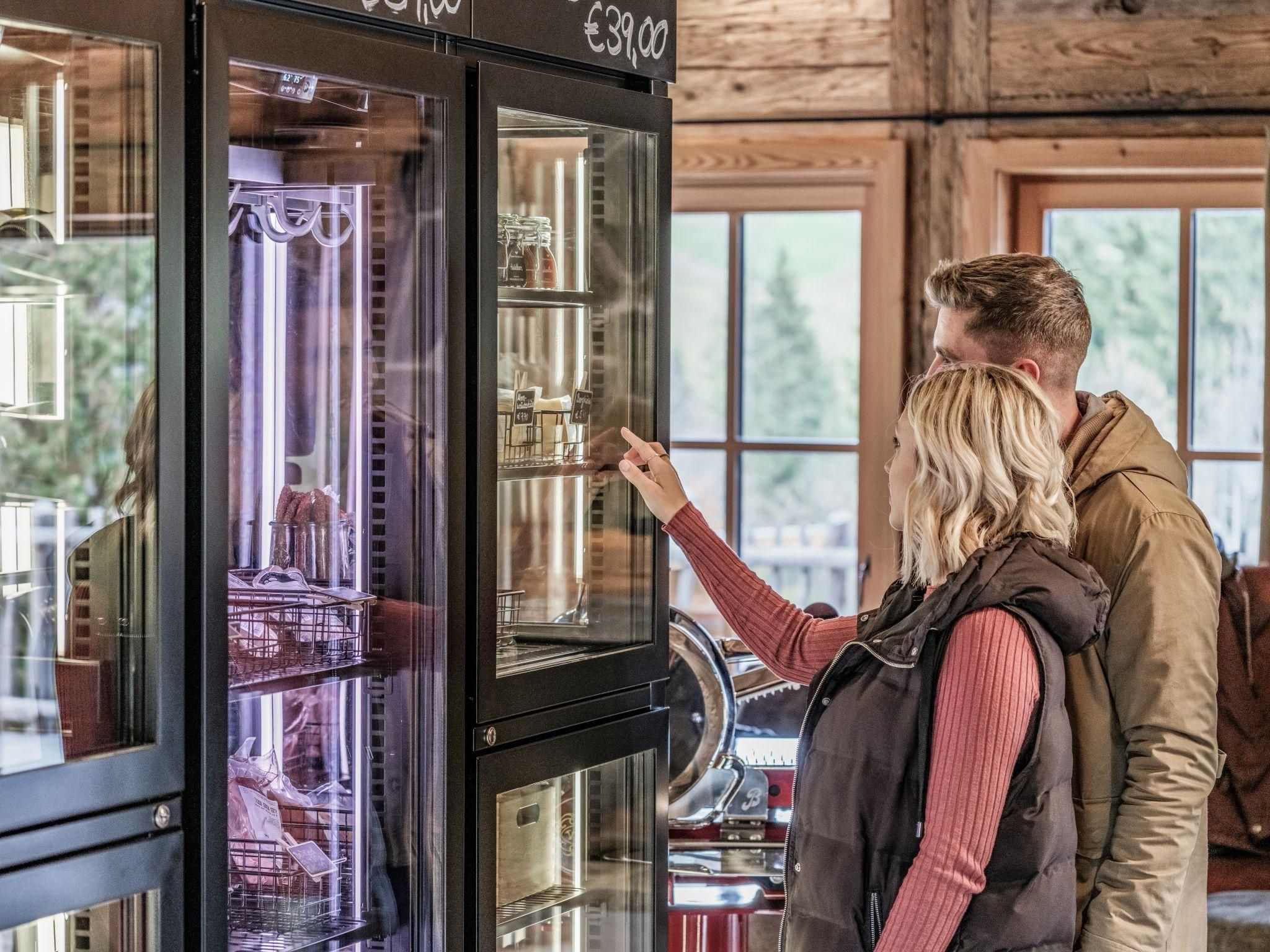 A couple is looking at a glass counter filled with snacks and drinks. The atmosphere is cozy and inviting.