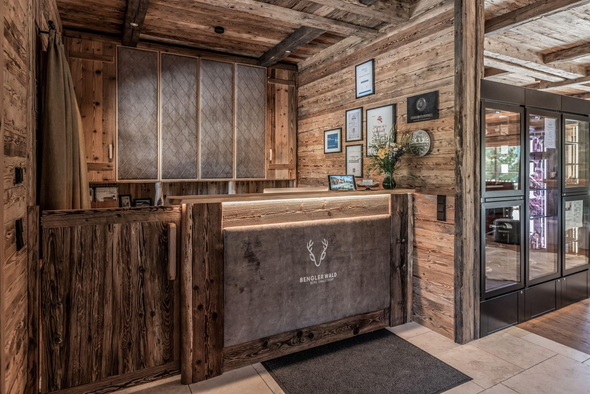 A cozy reception area with wooden paneling and warm light. Certificates and awards are hanging on the wall.