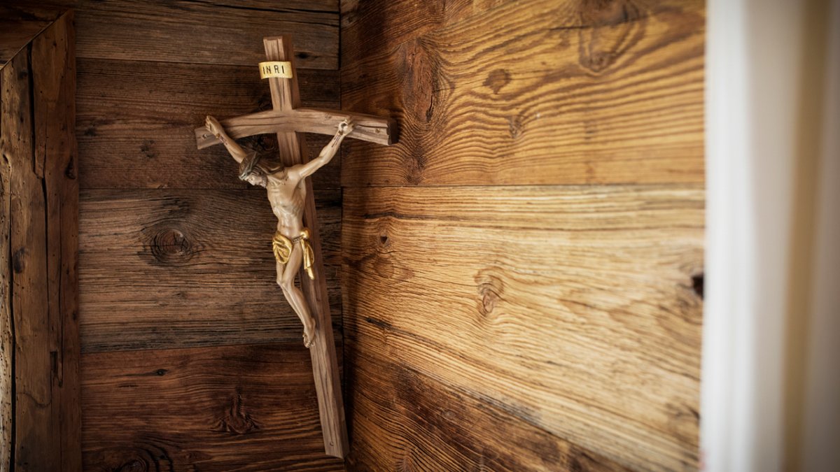 As in many farmsteads in Tirol there is a crucifix in the corner of the Chalet Friedlach, behind the table., © Tirol Werbung/Lisa Hörterer