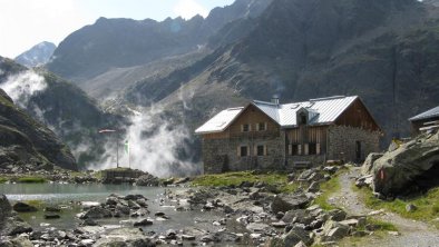 Winnebachseehütte mit See und Wasserfall