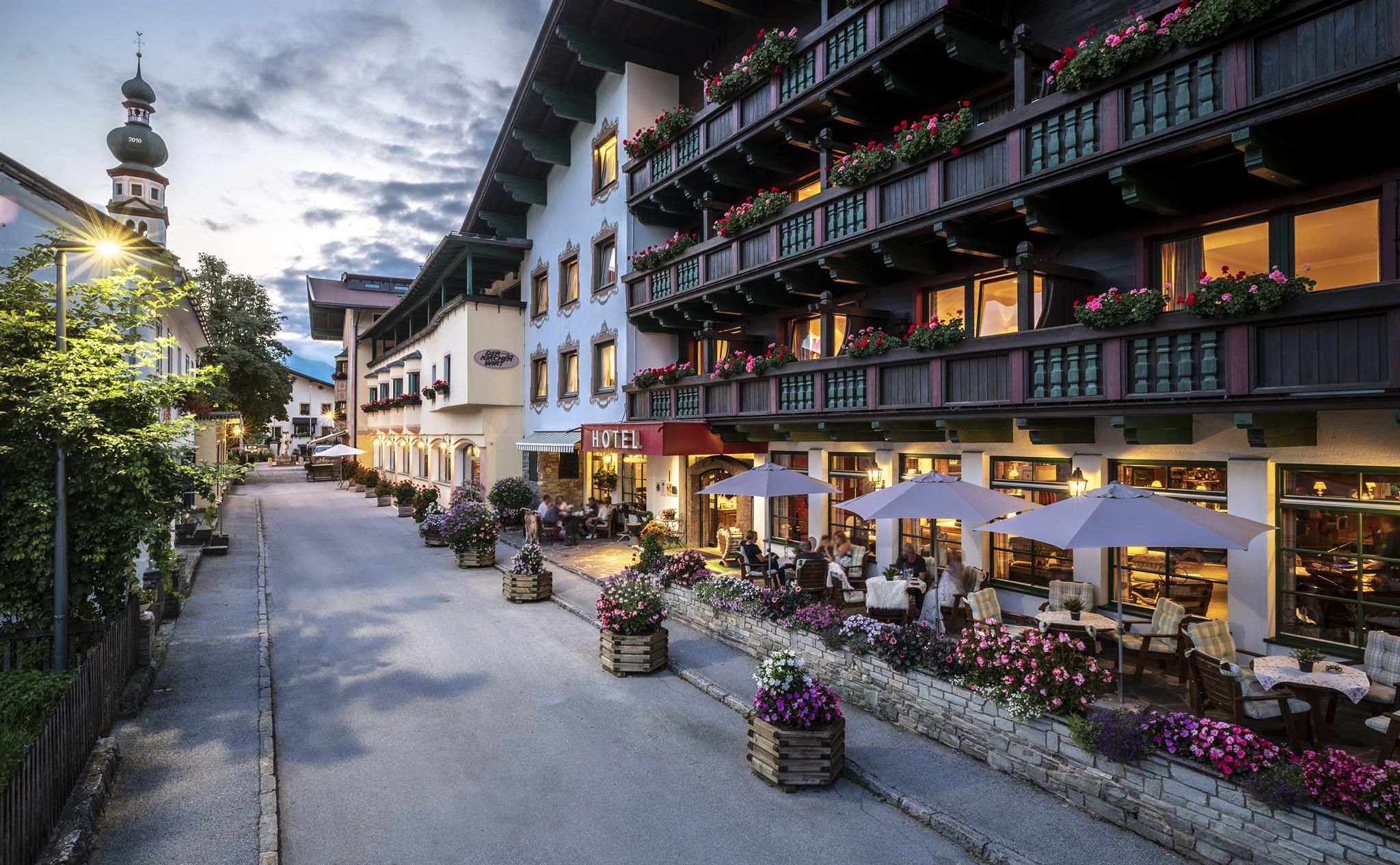 A charming hotel on a picturesque street, surrounded by blooming plants. The terrace invites you to linger and the architecture showcases alpine elegance.