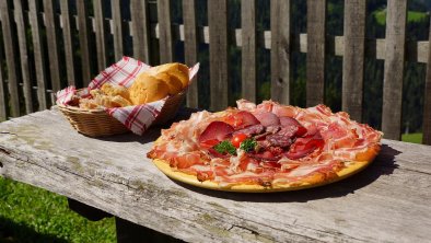 Jause mit Speckplatte im Garten genießen