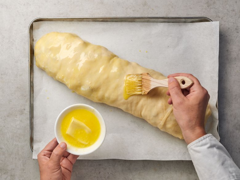 Step 10: Brush melted butter onto the strudel and place it in the pre-heated oven.