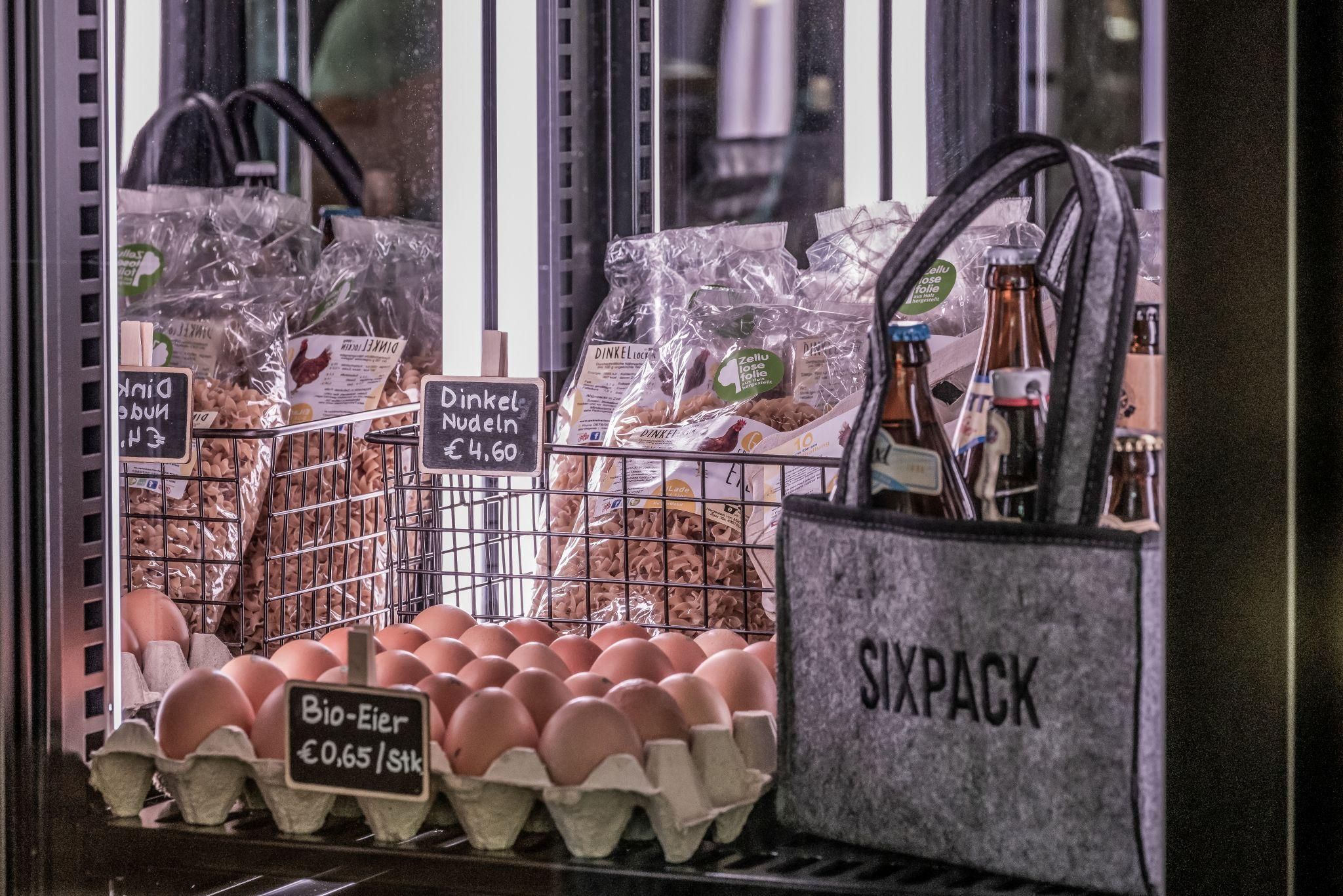 In the refrigerated shelf are fresh organic eggs and various pasta. Next to it is a bag with the print "SIXPACK".