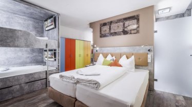 Family room with a box-spring bed and two Cubo sleeping-boxes, © Florian Mitterer / Cubo Sport&Art Hotel