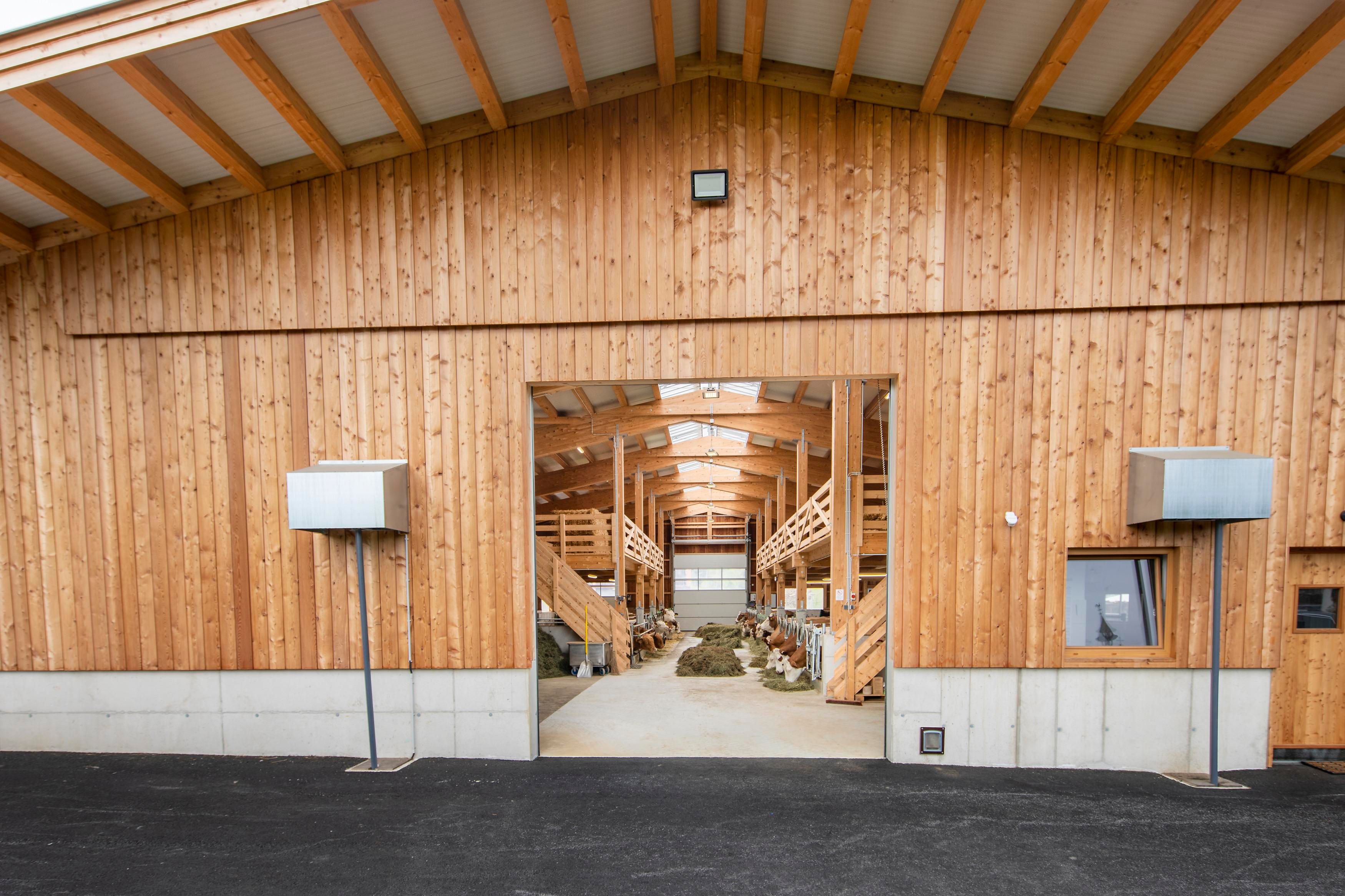 A large wooden barn with an open entrance. Inside, there are shelves and a bright, friendly atmosphere.